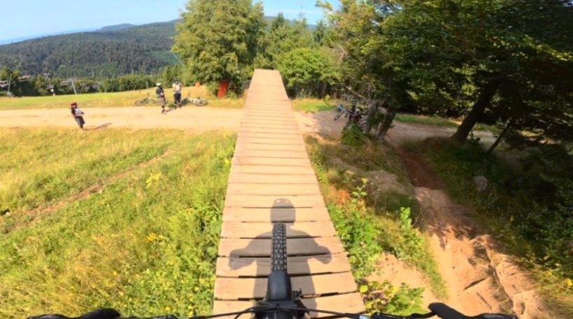 Vue depuis le guidon, passerelle en bois dans un bike park